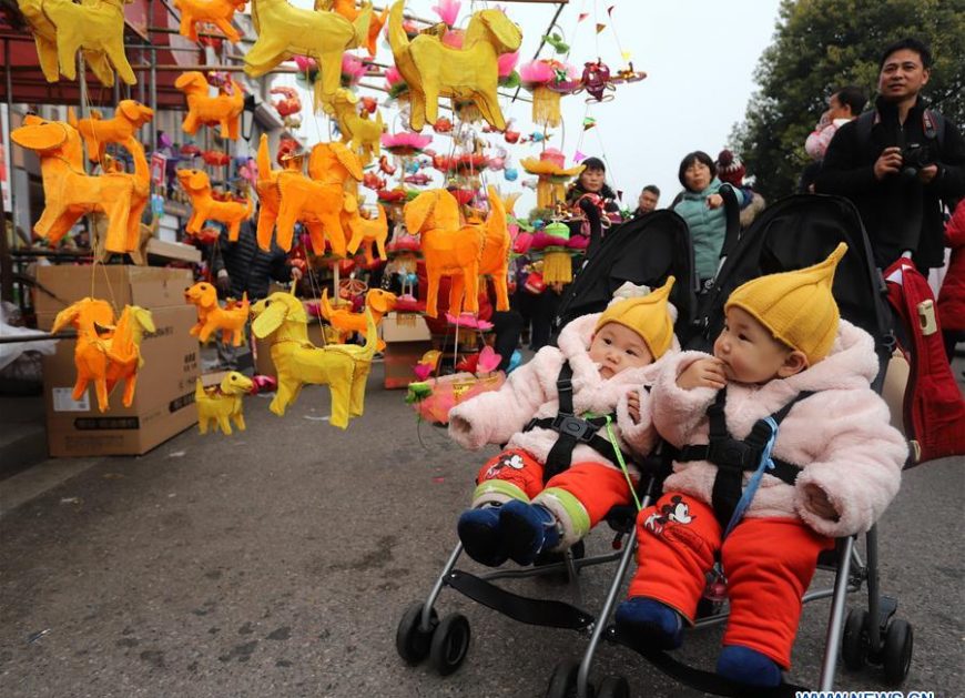 Children are attracted by lanterns at a lantern market in Nanjing, capital of east China's Jiangsu Province, Feb. 25, 2018. People buy colorful lanterns to greet the upcoming Lantern Festival.