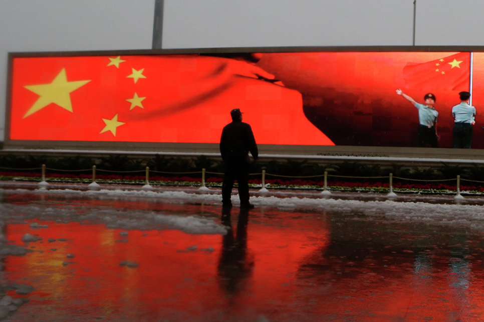 Человек на фоне экрана с китайским флагом, исключили из Компартии за коррупцию