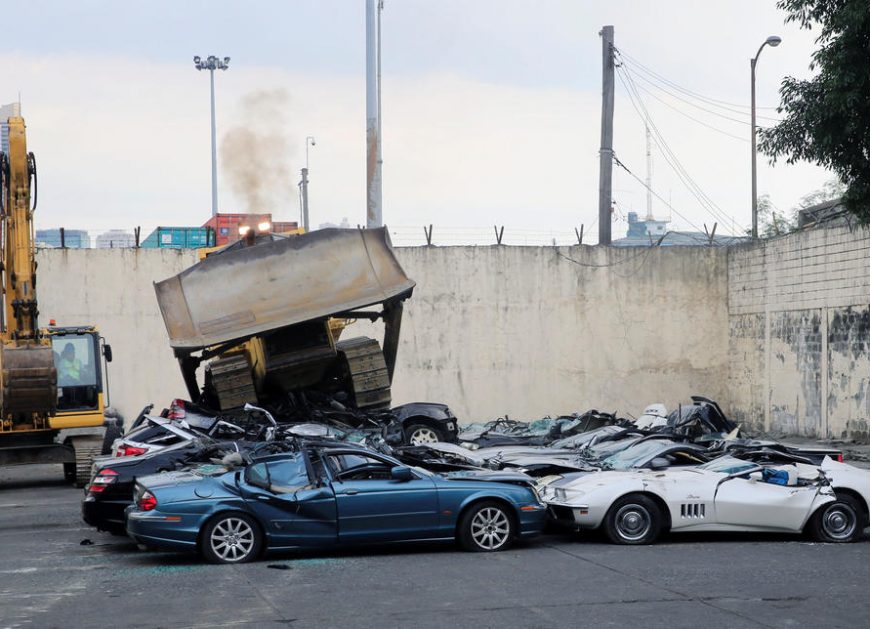 A bulldozer destroys condemned smuggled luxury cars worth 61,626,000.00 pesos during the 116th Bureau of Customs