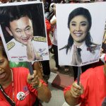 экс-премьеры Таиланда, Supporters of Pheu Thai Party, holding portraits of former Thai Prime Minister Thaksin Shinawatra, left, and his sister Yingluck Shinawatra, cheer up outside Parliament in Bangkok, Thailand, on Friday, Aug. 5, 2011. Thai lawmakers chose U.S.-educated businesswoman Yingluck as the country's first female prime minister Friday, setting the stage for the 44-year-old political novice to take charge of a volatile nation that's been deeply divided since her brother was ousted in a 2006 coup.