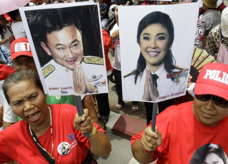 экс-премьеры Таиланда, Supporters of Pheu Thai Party, holding portraits of former Thai Prime Minister Thaksin Shinawatra, left, and his sister Yingluck Shinawatra, cheer up outside Parliament in Bangkok, Thailand, on Friday, Aug. 5, 2011. Thai lawmakers chose U.S.-educated businesswoman Yingluck as the country's first female prime minister Friday, setting the stage for the 44-year-old political novice to take charge of a volatile nation that's been deeply divided since her brother was ousted in a 2006 coup.
